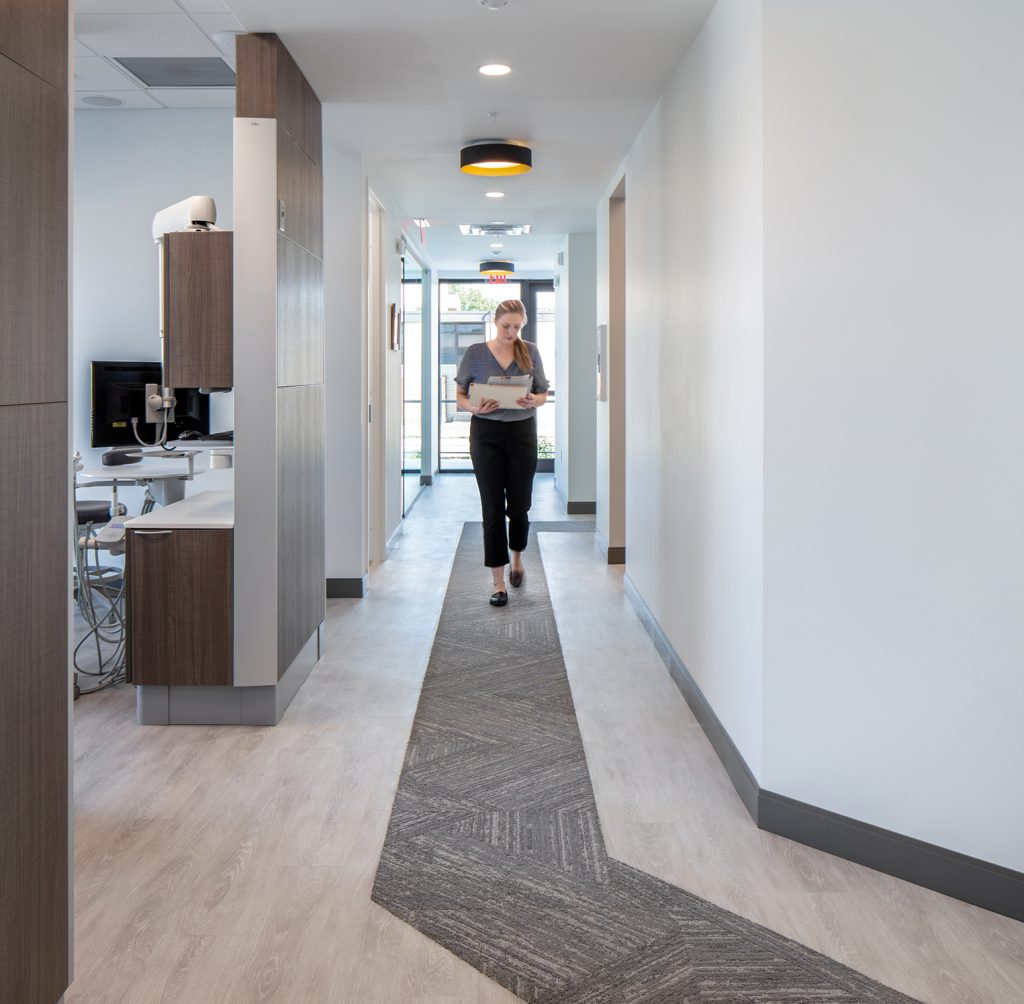 Woman walking down wide treatment hallway